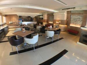 Un restaurante con mesas y sillas en una sala. en ZUZU Simpang Lima, en Semarang