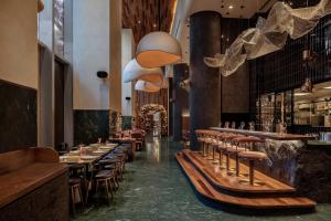 un restaurante con taburetes de madera y un bar en Luxury Grande 48 with Burj Khalifa & Fountain Views, en Dubái