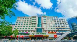 un grand bâtiment blanc avec de nombreux panneaux. dans l'établissement Zhaoqing Shanshui Fashion Hotel Duanzhou Road Branch, à Zhaoqing