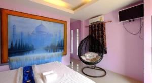 Cette chambre dispose d'un lit et d'une peinture murale. dans l'établissement Sixty-nine Resort, à Ban Tha Khwai