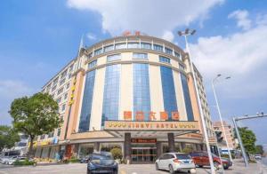 um prédio grande com carros estacionados em frente a ele em Guangzhou Jing Yi hotel em Huadu