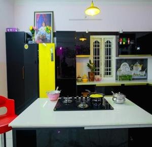 uma cozinha com um fogão e um frigorífico amarelo em The Sunshine Villa em Pondicherry
