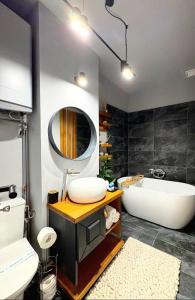 a bathroom with a tub and a sink and a mirror at ParkView in Craiova +11 photos
