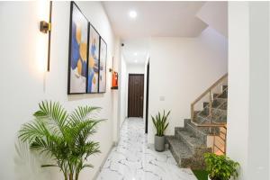 Un pasillo con plantas y escaleras en una casa. en FabHotel ASP Royal Residency I, en Nueva Delhi