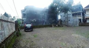 a small car parked in a yard next to a building at InnBox Capsule Hotel in Jember