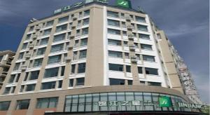 um prédio alto com uma placa no topo em Jinjiang Inn Style Ningxia Guyuan Beijing Road em Guyuan