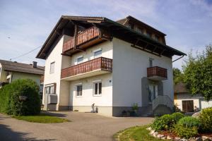 ein großes weißes Gebäude mit Holzbalkonen darauf in der Unterkunft Ferienwohnung Messner-Schauer in Sankt Kanzian am Klopeiner See