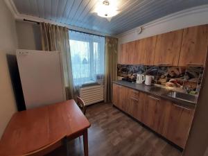 a kitchen with wooden cabinets and a sink and a table at Korter in Narva