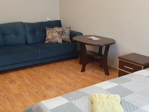 a living room with a blue couch and a table at Korter in Narva