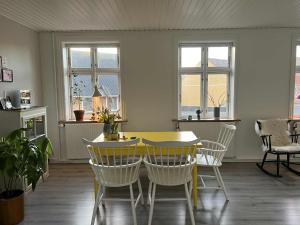 a dining room with a yellow table and chairs at Solskinshuset in Hasle