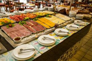 um buffet com muitos tipos diferentes de comida em uma mesa em Resort Arcobaleno All Inclusive em Porto Seguro