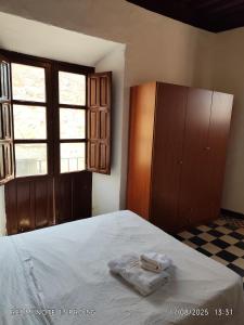 a bedroom with a bed with two towels on it at Gustavo's Old House in Fiñana