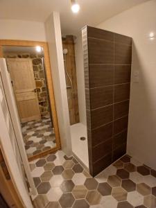 a bathroom with a shower and a tile floor at Gîte au cœur des Gorges du Tarn in Saint-Rome-de-Dolan +11 photos