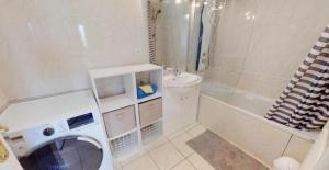 a white bathroom with a washing machine in it at Appartement typique Gare Lille Flandre centre ville in Lille