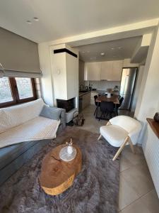 a living room with a couch and a table at Armonia Suites Livadi Arachovas in Arachova