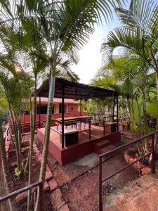 Shantai Luxury Homestay, Malgund في Mālgund: جناح مع طاولة نزهة واشجار النخيل