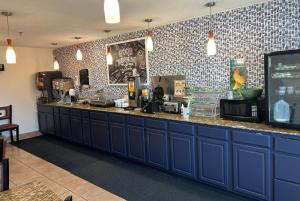 a kitchen with blue cabinets and a counter top at AmericInn by Wyndham Mosinee Central Wisconsin Airport in Mosinee