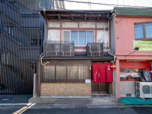 a building with two chairs and a balcony at kyomachiya-京町家Oneworld十条-Jujo in Kyoto