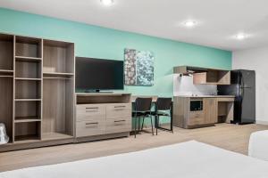 a room with a tv and a desk with chairs at Echo Suites Extended Stay by Wyndham Atlanta-Conyers in Conyers