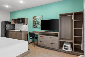 a bedroom with a bed and a flat screen tv at Echo Suites Extended Stay by Wyndham Atlanta-Conyers in Conyers