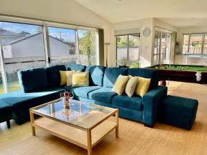 un salon avec un canapé bleu et une table de billard dans l'établissement The Coastal Haven, à Manyana