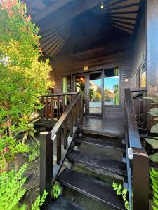 une terrasse couverte d'une maison avec un escalier en bois dans l'établissement Island Cabanas Formerly Taman Sari Villa, à Nusa Lembongan
