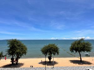 โรงแรม เซิร์ฟบีช Surf Beach Hotel في جومتين بيتش: شاطئ فيه اشجار في الرمال والمحيط