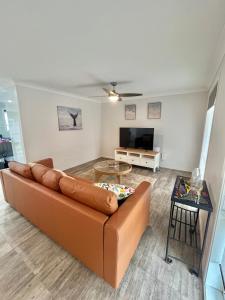 a living room with a couch and a table at The Burra Spa, Games & Beach House in Culburra Beach