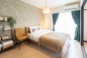 a bedroom with a bed and a window and a chair at 栗林公園の畔 in Takamatsu