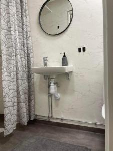 a bathroom with a sink and a mirror on the wall at Övernattningsrum - Ryttaren in Varberg