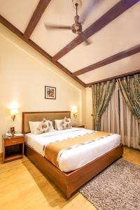 a bedroom with a large bed with a ceiling at Foxoso Misty Oaks - Hotel & Resort in Bhowāli