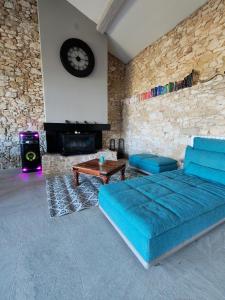 Una sala de estar con un sofá azul y una chimenea. en Le grand gîte du Causse, en Cuq-Toulza