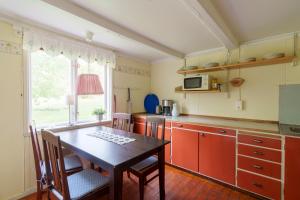 a kitchen with a table and a table and a window at Horsvik - Hagstugan in Studsvik