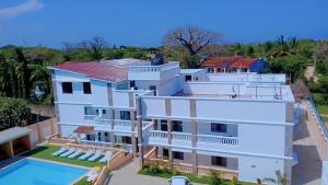 an aerial view of a white building with a swimming pool at Charming chalet Diani in Diani Beach