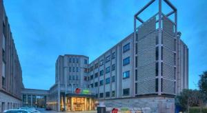 a large white building with a sign on it at New Century Manju Hotel Shanghai New International Expo Center in Shanghai