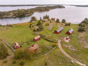 an aerial view of a farm on a hill near a body of water at Horsvik - Hagstugan in Studsvik