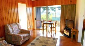 a living room with a chair and a table and a television at Fletcher Christian Holiday Hotel in Kingston