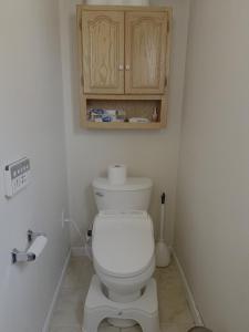 a bathroom with a white toilet and a cabinet at Fan's Family in Tracy