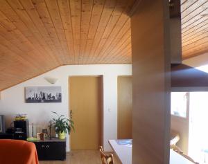 a room with a wooden ceiling and a table at Apartment Doderovic in Kostrena