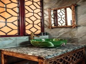 a bathroom with a green bowl on a counter at Guilin Lotus Hotel in Guilin +181 photos