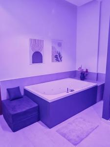 a large bath tub with a purple stool in a bathroom at Isensi Luxury Suite Trani in Trani +16 photos