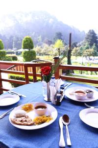a table with plates of food on a blue table cloth at Foxoso Misty Oaks - Hotel & Resort in Bhowāli