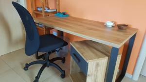 a desk with a black chair and a wooden table at Ferienwohnung Bär in Schwäbisch Hall