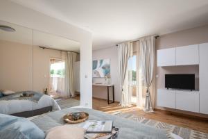 a living room with two beds and a television at Luxury Villa San heated pool sauna in Sveti Filip i Jakov