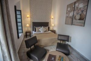 a hotel room with two beds and a chair at Riad Villa Wengé & Spa in Marrakesh