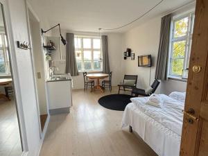 a bedroom with a bed and a kitchen and a table at Villa Koch X Pension Koch in Gudhjem