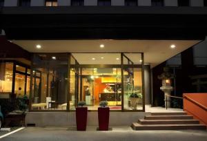 a building with two potted plants in front of it at Hotel 1-2-3 Kofu Shingen Onsen in Showa