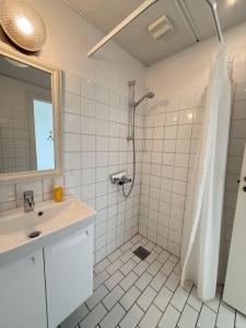 a white bathroom with a shower and a sink at Villa Koch X Pension Koch in Gudhjem +41 photos