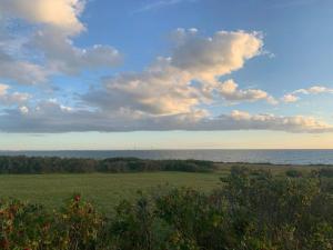 un champ ouvert avec l'océan en arrière-plan dans l'établissement 9 person holiday home in Gørlev-By Traum, à Venemose