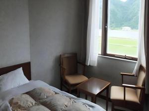 a bedroom with a bed and a chair and a window at Sento Otani Hotel in Toyooka +153 photos